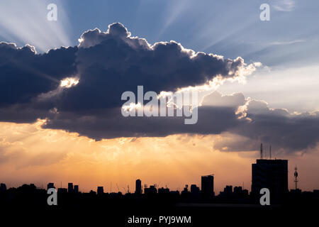 Sunbeam à travers les nuages spectaculaires pendant l'heure du coucher du soleil, avec l'ossature des capacités en arrière-plan Banque D'Images