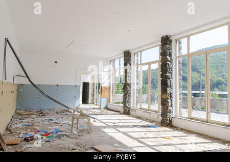 Scène lumineuse d'un ancien restaurant - salle vide et abandonné avec l'ordure qui brille dans la lumière du matin Banque D'Images