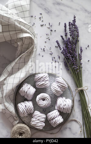Mise à plat d'une plaque de guimauves (zephyr, meringue) réalisés avec la lavande sur fond blanc pierre marmor Banque D'Images