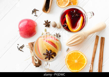 Deux verres de différents type de vin chaud ou de gluhwein basé sur les vins rouge et blanc avec des épices et ingrédients on white background. Guerre épicé Banque D'Images