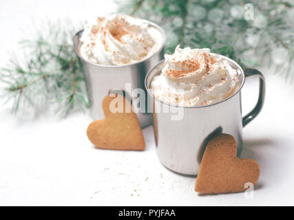Boisson chaude avec de la crème fouettée et les cookies en forme de coeur, des tasses de café ou de cacao, concept d'hiver romantique Banque D'Images