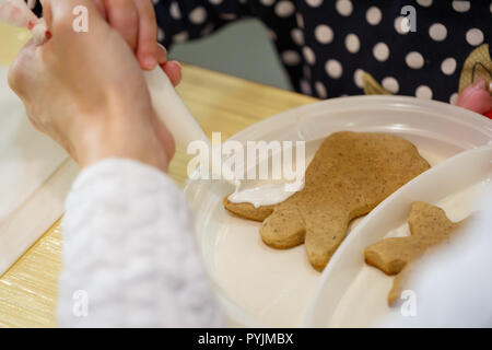Mère et fille décorer les cookies pour la maison de vacances Banque D'Images