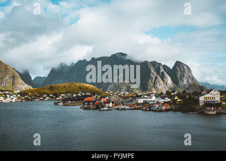 Paysage du village de pêche Reine avec la Reine Fjord pendant le coucher du soleil avec de belles lumières sur montagne, ciel bleu et nuages. Lofoten, Norvège. Photo prise Banque D'Images