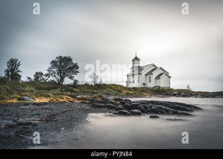 Une longue exposition de l'église blanche de Gimsoy de rochers et l'océan atlantique. Photo prise sur l'île de Lofoten, Norvège Gimsoy. Photo prise en Norvège. Banque D'Images