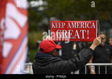 New York, États-Unis 28 octobre 2018. Un contre-manifestant soutenant le président détient un atout pro-Trump signe alors que les protestataires anti-Trump demande sa destitution rassemblement à New York's Battery Park à côté d'un ballon de 20 pieds représentant le président comme un bébé en couches. Les manifestants ont utilisé des ballons semblables dans d'autres manifestations anti-Trump aux États-Unis et au Royaume-Uni Le rallye et mars a été organisée par un groupe appelé par le peuple qui accuse le président d'avoir commis des crimes et délits majeurs. Crédit : Joseph Reid/Alamy Live News Banque D'Images