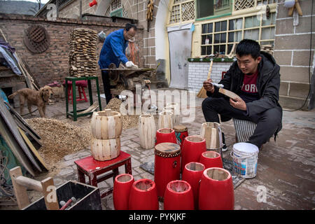 (181029) -- Yan'an, le 29 octobre 2018 (Xinhua) -- Wang Yongjun (L) et son fils faire taille de la batterie à Fengjiaying Village de Ansai, District de la ville de Yan'an, province du Shaanxi du nord-ouest de la Chine, le 19 octobre 2018. Ansai District, situé dans la partie nord de la province du Shaanxi, sur le Plateau de Loess, est largement connu pour son unique folk arts comme Ansai Waist Drum Dance, papier, chants folkloriques, la peinture et l'opéra. Au cours des dernières années, Ansai a fait des efforts pour stimuler le tourisme culturel en intégrant le tourisme avec ces arts populaires unique afin d'aider à l'éradication de la pauvreté. Après une formation, les gens peuvent compléter leurs dans Banque D'Images
