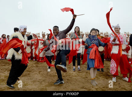 (181029) -- Yan'an, le 29 octobre 2018 (Xinhua) -- les étudiants étrangers effectuer Ansai waist drum dance avec les danseuses à Nangou Village de Ansai, District de la ville de Yan'an, dans le nord-ouest de la Chine, dans la province de Shaanxi, du 20 octobre 2018. Ansai District, situé dans la partie nord de la province du Shaanxi, sur le Plateau de Loess, est largement connu pour son unique folk arts comme Ansai Waist Drum Dance, papier, chants folkloriques, la peinture et l'opéra. Au cours des dernières années, Ansai a fait des efforts pour stimuler le tourisme culturel en intégrant le tourisme avec ces arts populaires unique afin d'aider à l'éradication de la pauvreté. Après une formation, les gens peuvent sup Banque D'Images