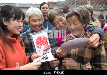 (181029) -- Yan'an, le 29 octobre 2018 (Xinhua) -- Wang Qin (L) les échanges de compétences avec le coupe-papier anciens dans Embassy Suite Ville située dans le district de Ansai, Yan'an, ville du nord-ouest de la Chine, dans la province de Shaanxi, du 20 octobre 2018. Ansai District, situé dans la partie nord de la province du Shaanxi, sur le Plateau de Loess, est largement connu pour son unique folk arts comme Ansai Waist Drum Dance, papier, chants folkloriques, la peinture et l'opéra. Au cours des dernières années, Ansai a fait des efforts pour stimuler le tourisme culturel en intégrant le tourisme avec ces arts populaires unique afin d'aider à l'éradication de la pauvreté. Après une formation, les gens peuvent suppl Banque D'Images