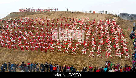 (181029) -- Yan'an, le 29 octobre 2018 (Xinhua) -- photo aérienne prise le 20 octobre 2018 montre une performance d'Ansai waist drum dance à Nangou Village de Ansai, District de la ville de Yan'an, province du Shaanxi du nord-ouest de la Chine. Ansai District, situé dans la partie nord de la province du Shaanxi, sur le Plateau de Loess, est largement connu pour son unique folk arts comme Ansai Waist Drum Dance, papier, chants folkloriques, la peinture et l'opéra. Au cours des dernières années, Ansai a fait des efforts pour stimuler le tourisme culturel en intégrant le tourisme avec ces arts populaires unique afin d'aider à l'éradication de la pauvreté. Après une formation, les gens peuvent sup Banque D'Images