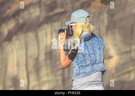 Traveler femme photographe avec appareil photo reflex au monastères des Météores en Grèce Centrale, l'Europe. Les femmes de race blanche de photographier un monument grec populaire. Banque D'Images