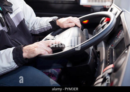 Chauffeur de camion, les mains sur le volant, assis dans le véhicule. Banque D'Images