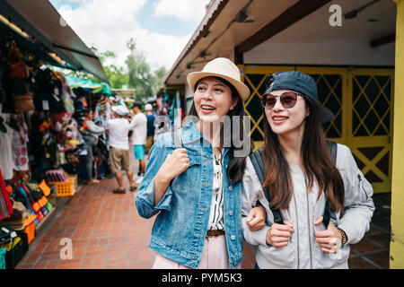 Deux amis marchant joyeusement sur le marché et, curieusement, à la recherche de la même chose. Voyages USA Des vacances pour profiter de la ville. jeune fille d' Banque D'Images