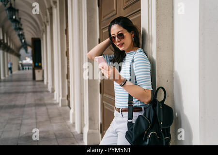 Jolie étudiante attendant son ami sur le passage après le cours. En étudiant l'extérieur Balcon dame souriant heureux de retourner à l'accueil adolescent. Banque D'Images