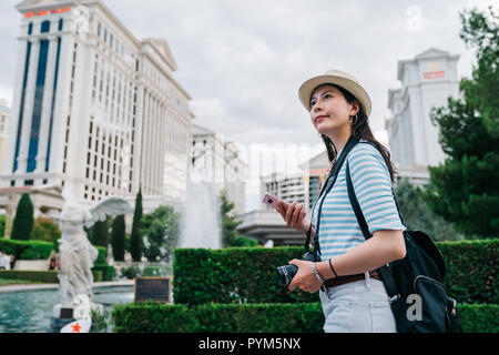 Meilleur marche à travers la fontaine dans le centre ville avec de grands bâtiments autour. jeune photographe appréciant la vue urbaine dans quartier animé. w Banque D'Images