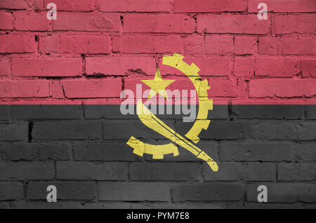Drapeau de l'Angola est peint sur un vieux mur de brique Banque D'Images