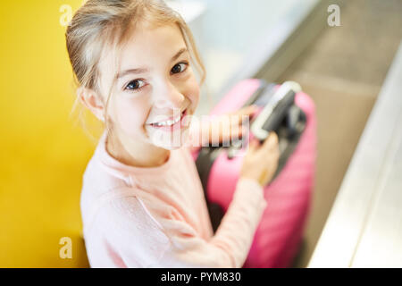 Petite fille en tant que passager avec des valises à l'arrivée au terminal de l'aéroport voyage seule Banque D'Images