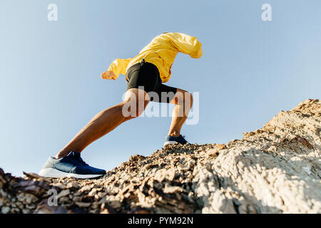 Athlète masculin grimpe une montagne escarpée concept pour surmonter les difficultés. Banque D'Images