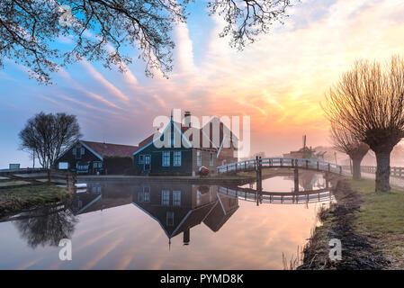 De belles maisons en bois typiquement néerlandais et en miroir de l'architecture sur le canal calme de Zaanse Schans situé au nord d'Amsterdam, Pays-Bas Banque D'Images