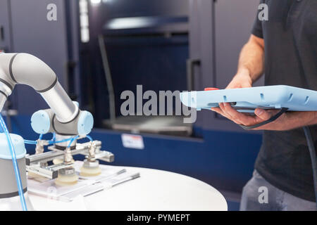 Un technicien d'exploitation et programmation le bras robotique. Banque D'Images