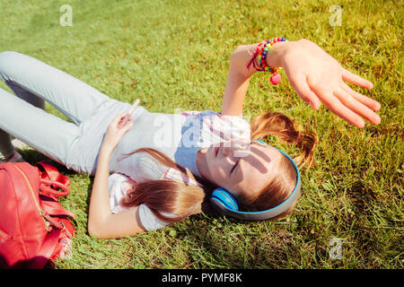 L'écoute de l'adolescent détendue musique préférée dans park Banque D'Images