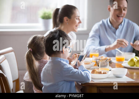 Famille avec enfants ayant le petit déjeuner dans la cuisine Banque D'Images