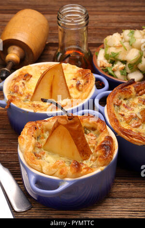 Poires au four en feuilleté avec les écrous à fond rustique en bois Banque D'Images