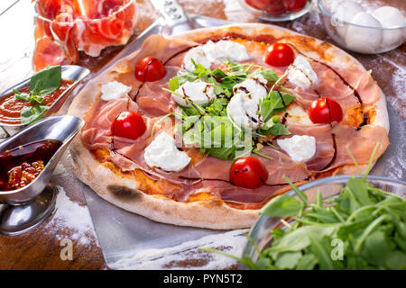 Close up of delicious italian pizza au jambon, mozzarella, tomates et roquette Banque D'Images