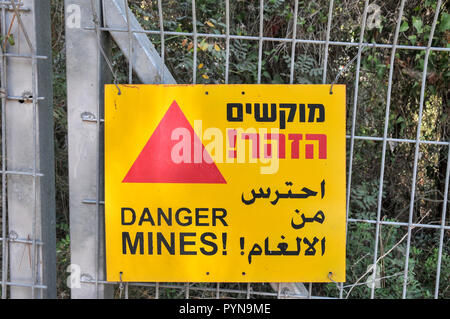 Israël, un champ de mines, un panneau d'avertissement jaune en Hébreu, Arabe et anglais "Danger Mines !' Banque D'Images