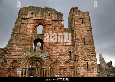 Face de l'église du monastère de Lindisfarne et ruines du prieuré médiéval avec flèche croisée sur l'île Sainte des boucles de Lindisfarne England UK Banque D'Images