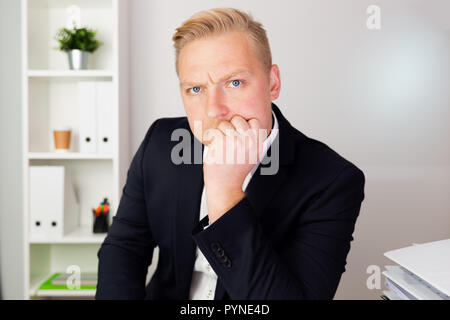 Businessman looking sérieusement dans un costume bleu foncé et la pensée. Les dirigeants de l'entreprise concept. Banque D'Images