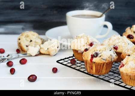 Muffins aux canneberges sur une boulangerie rack de refroidissement avec une extrême profondeur de champ et ouvert avec du beurre et de muffins un bon café dans le bac Banque D'Images