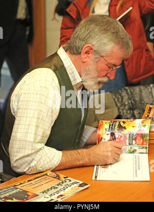 L'ancien chef Sinn Fein Gerry Adams signe des copies de son livre de recettes intitulé le livre de recettes des négociateurs au Culturlande sur la route des chutes à Belfast. Banque D'Images