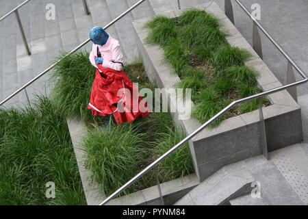 Un artiste dans l'espace public. Une fille fait de l'art performance à Milan dans un espace public. Artistique de danse. Banque D'Images