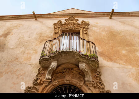 Façade d'une maison avec balcon en fer forgé et corniche en stuc très ornée dans la ville médiévale fortifiée d'Erice, Sicile, Italie. Banque D'Images