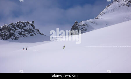 Plusieurs randonneurs grimper et franchir un grand glacier dans les Alpes Suisses près de Disentis sur leur façon d'une crête de montagne à distance sur un magnifique w Banque D'Images