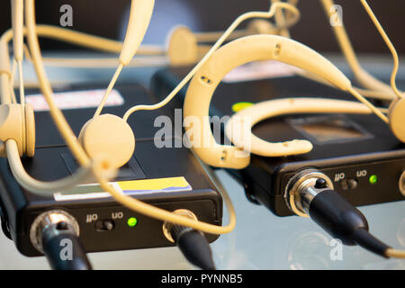 Head set microphones sans fil émetteur et récepteur de microphone sans fil deux sur une table en verre dans un studio de télévision Banque D'Images