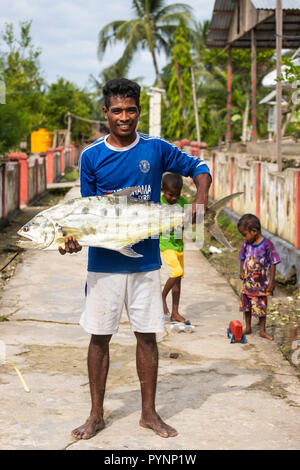 TUNGU VILLAGE, îles Aru, Indonésie, 06 décembre 2017 : fier pêcheur est montrant son gros poisson dans le village Tungu, îles Aru, Papouasie, Indonésie. Banque D'Images