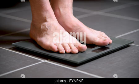 Pieds masculins sur les échelles en verre, l'alimentation, du poids corporel, Close up Banque D'Images