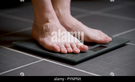 Pieds masculins sur les échelles en verre, l'alimentation, du poids corporel, Close up Banque D'Images