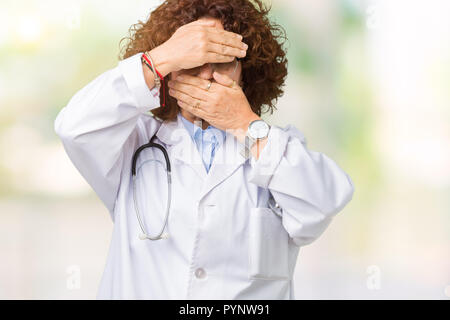 Ager au médecin senior femme de plus fond isolé couvrant les yeux et la bouche avec les mains, surpris et choqué. Cacher l'émotion Banque D'Images