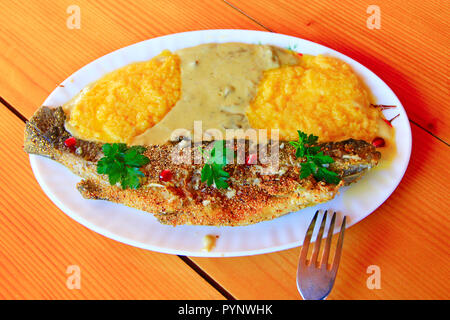 Frit avec banusz la truite. Plat d'une truite poêlée et banusz avec soupe aux champignons. Délicieux plat. Plat cuisiné au restaurant Banque D'Images