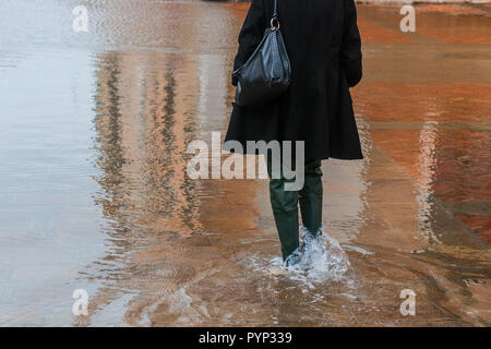 Venise, Italie. 29 octobre, 2018. Une femme avec des bottes de marche le 29 octobre 2018, à Venise, Italie. En raison du niveau exceptionnel de la "acqua alta" ou "marée haute" qui atteint 156 cm aujourd'hui, les écoles vénitienne et les hôpitaux ont été fermées par les autorités, et les citoyens ont été avisés de quitter leurs maisons. Ce niveau de marée haute a été atteinte en 1979. © Simone Padovani / éveil / Alamy Live News Banque D'Images