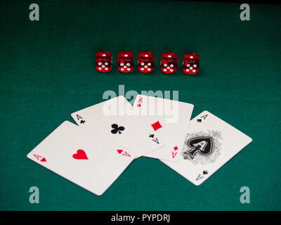 Les quatre as d'un jeu de poker et plusieurs dés sur un tapis vert Banque D'Images
