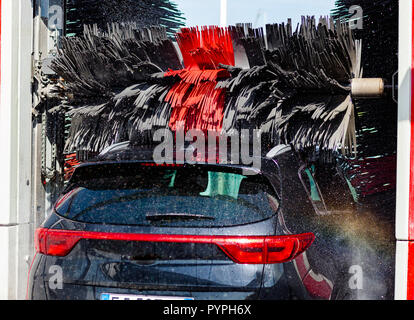 Black car en rotation automatique de lavage de voiture brosse rouge et noir. Lave-véhicule. Banque D'Images