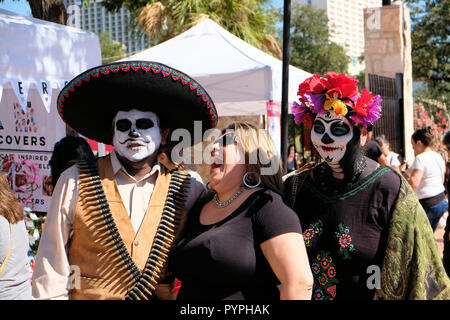 Célébrer le Jour des Morts à San Antonio, Texas, USA ; l'homme et la femme habillés en costume traditionnel mexicain avec des visages peints et femme en riant. Banque D'Images