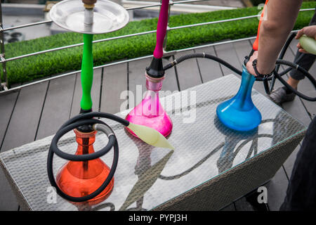 Trois couleurs hookahs sur table dans un salon à narguilé dans une journée. Banque D'Images