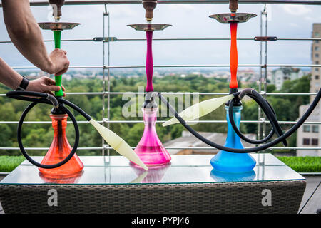 Trois couleurs hookahs sur table dans un salon à narguilé dans une journée. Banque D'Images