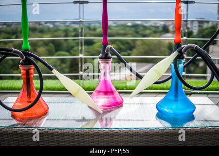 Trois couleurs hookahs sur table dans un salon à narguilé dans une journée. Banque D'Images