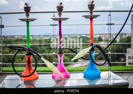 Trois couleurs hookahs sur table dans un salon à narguilé dans une journée. Banque D'Images