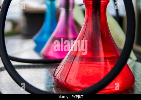 Trois couleurs hookahs sur table dans un salon à narguilé dans une journée. Banque D'Images